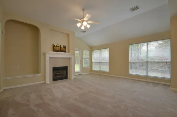 a view of an empty room with a fireplace and a window