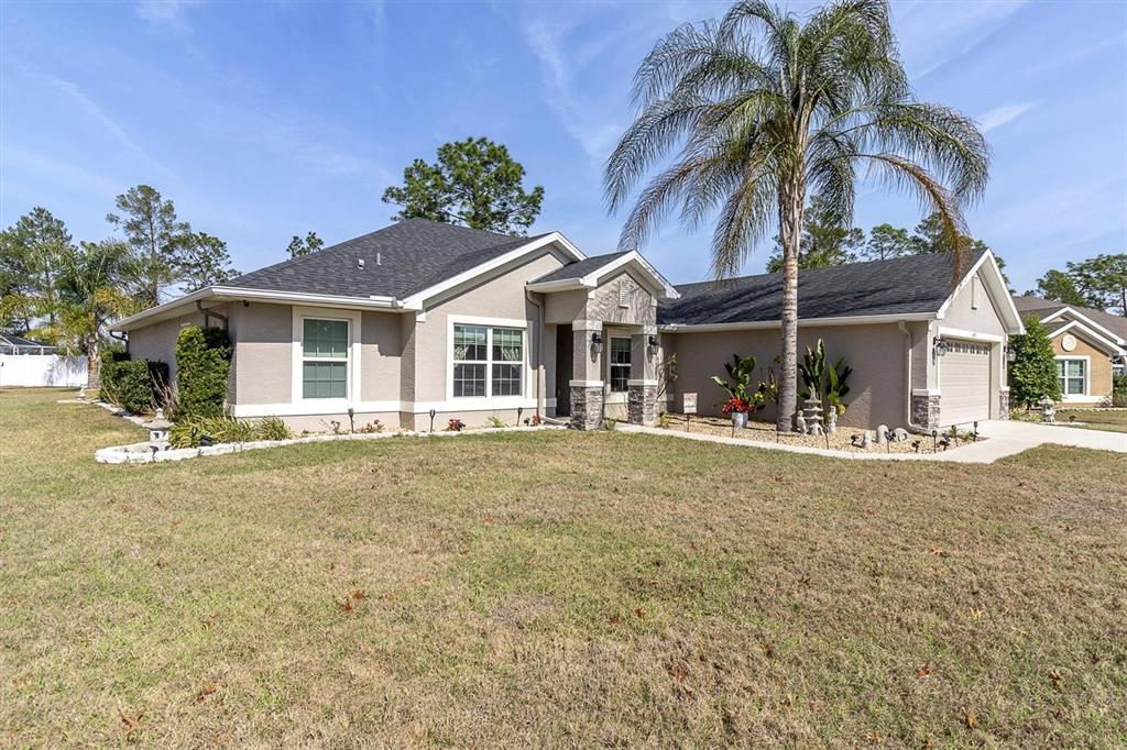 3455 Whispy Court Spring Hill, FL 34609 - Photo 37 of 42 a front view of a house with a garden and patio