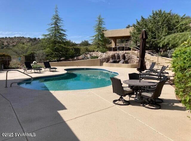 6745 North Canyon Road, Unit 104 Rimrock, AZ 86335 - Photo 11 of 31 a view of a swimming pool with lawn chairs under an umbrella