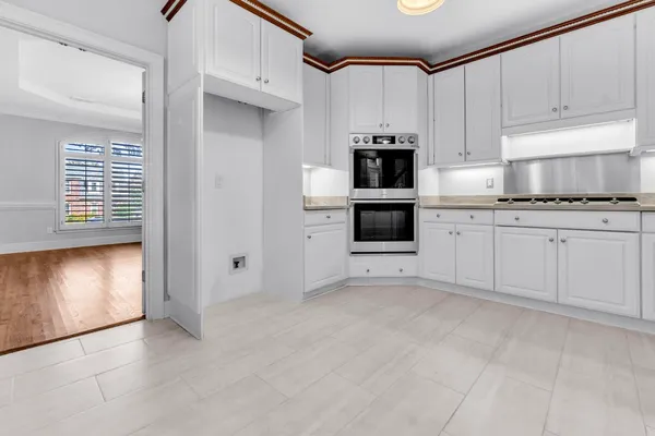 a kitchen with granite countertop white cabinets and white appliances