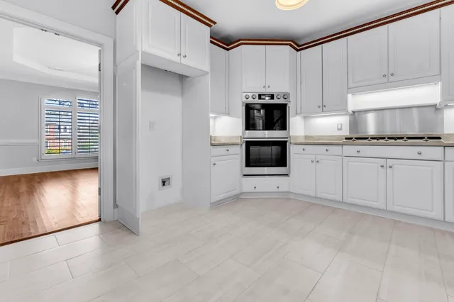 a kitchen with granite countertop white cabinets and white appliances