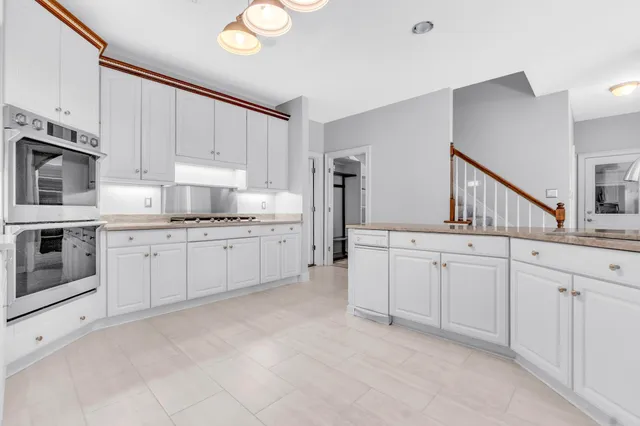 a kitchen with granite countertop white cabinets and white appliances