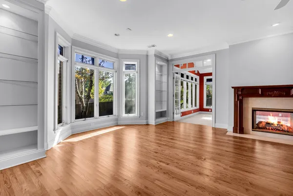 a view of an empty room with window and fire place