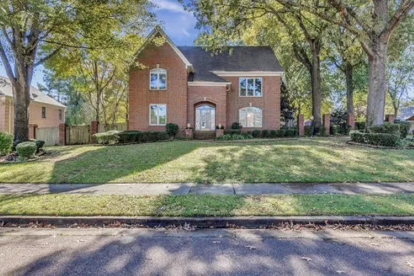 a front view of a house with a yard and a garage