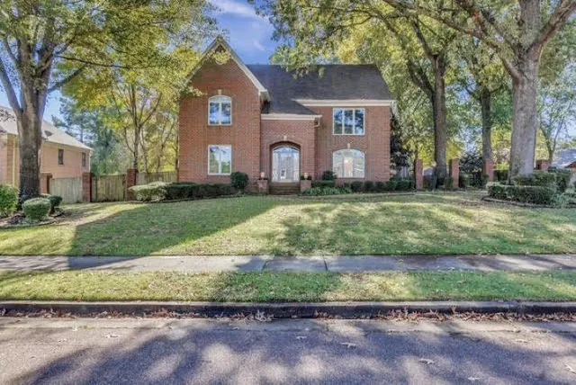 a front view of a house with a yard and a garage