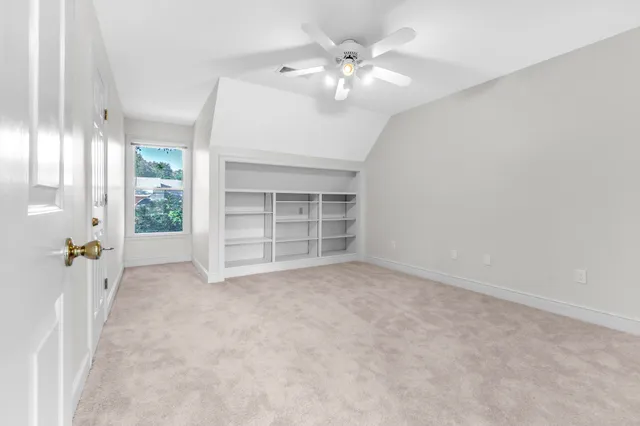 en empty room with windows and ceiling fan