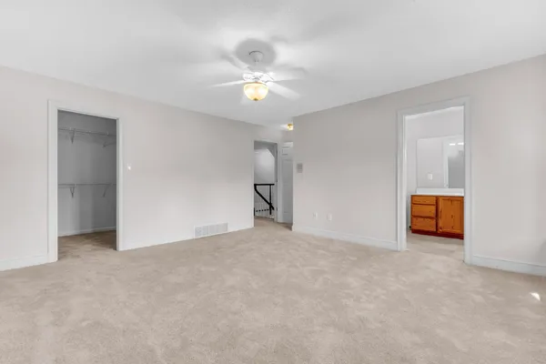 a view of an empty room with a chandelier fan