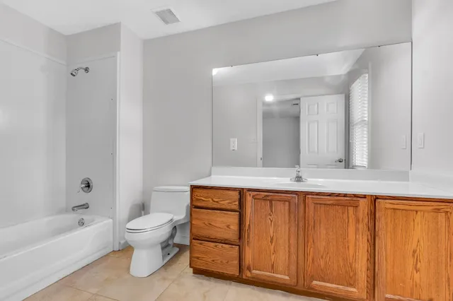 a bathroom with a sink a toilet a mirror and bathtub