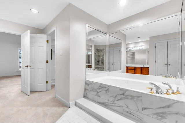 a bathroom with a tub and mirror