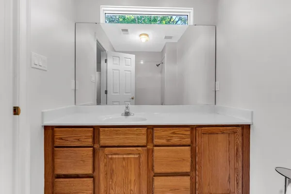 a bathroom with a sink a mirror and a window
