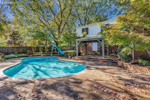 a view of a house with backyard and a tree