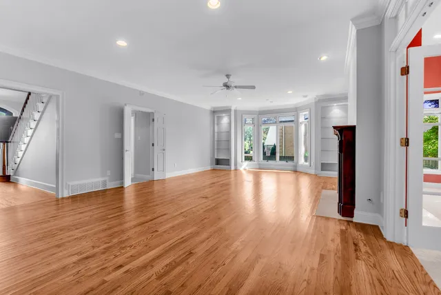 a view of a hallway with wooden floor and a window