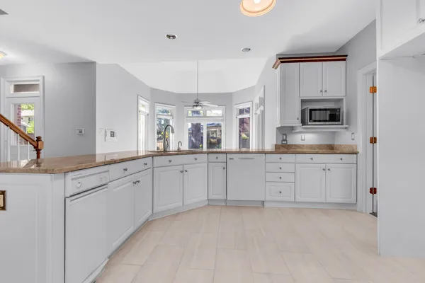 a spacious en suite bathroom with a granite countertop sink and mirror
