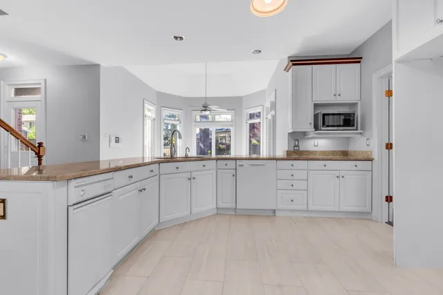 a spacious en suite bathroom with a granite countertop sink and mirror