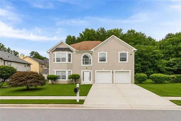 a front view of a house with a yard and garage