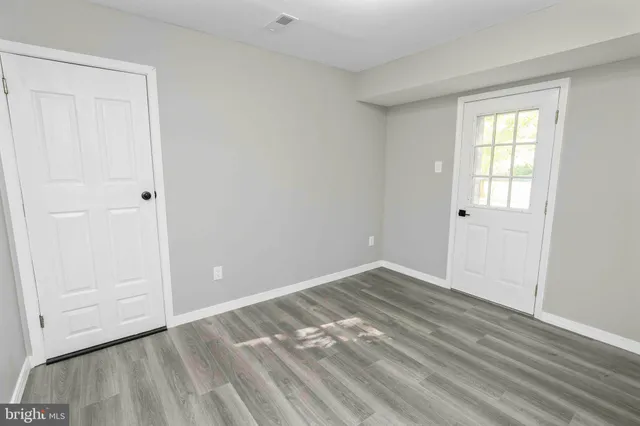 a view of empty room with wooden floor