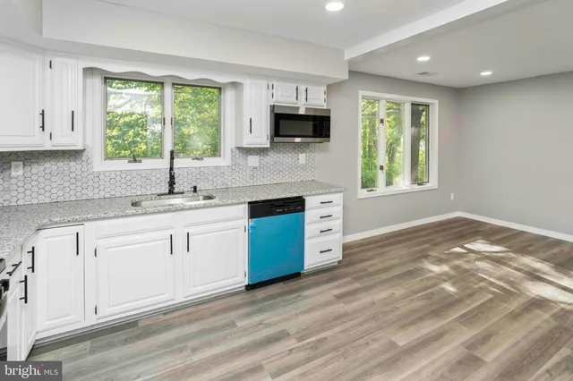 a large kitchen with stainless steel appliances granite countertop a large counter top and a stove