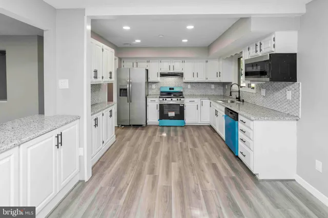 a kitchen with granite countertop a sink a microwave and cabinets