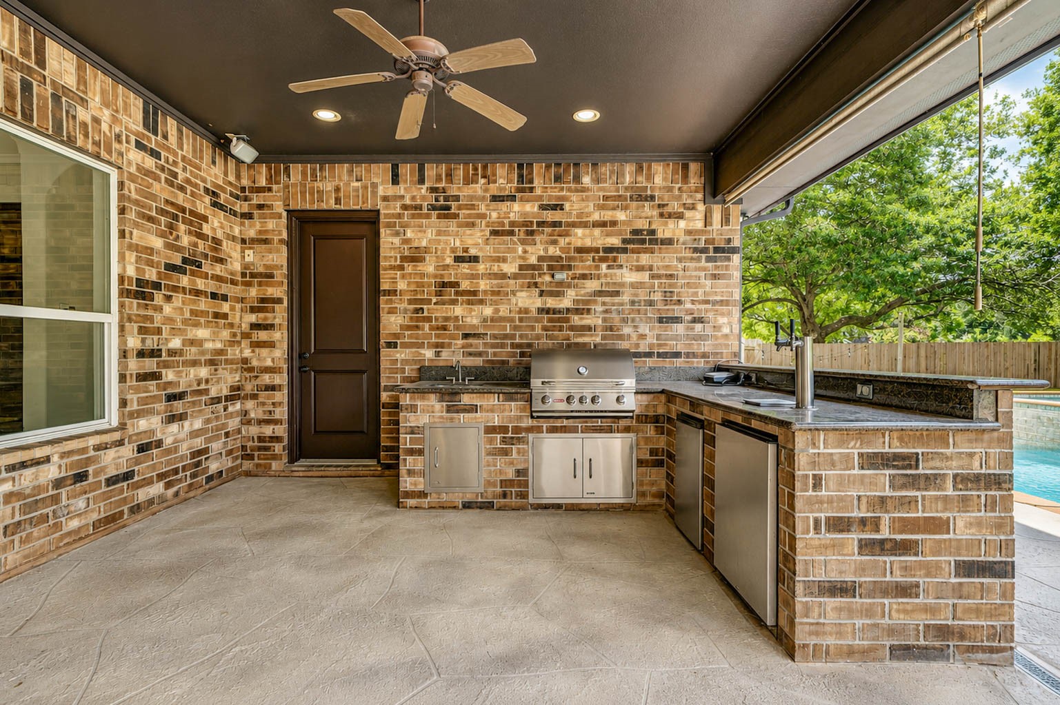 5327 Whitmore Fulshear, TX 77441 - Photo 37 of 50 Outdoor entertaining is effortless beneath the expansive covered patio featuring surround sound wiring and a fully equipped outdoor kitchen complete with a Bull gas grill, refrigerator, sink, and dual-tap kegerator.