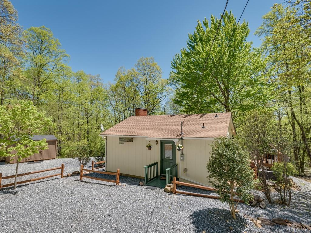 1251 Judes Gap Road Mill Spring, NC 28756 - Photo 2 of 35 an aerial view of a house with table and chairs under an umbrella