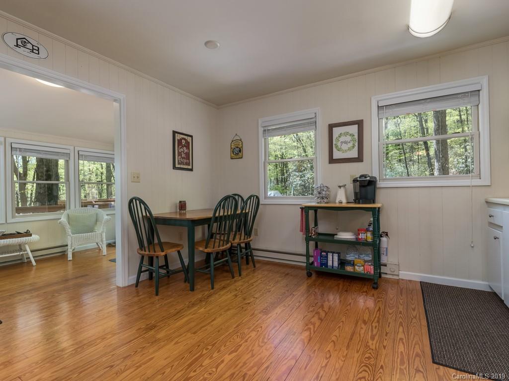 1251 Judes Gap Road Mill Spring, NC 28756 - Photo 12 of 35 a view of a dining room with furniture and wooden floor