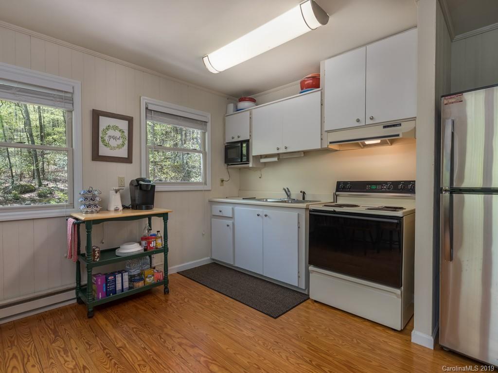 1251 Judes Gap Road Mill Spring, NC 28756 - Photo 13 of 35 a kitchen with appliances cabinets and a wooden floor