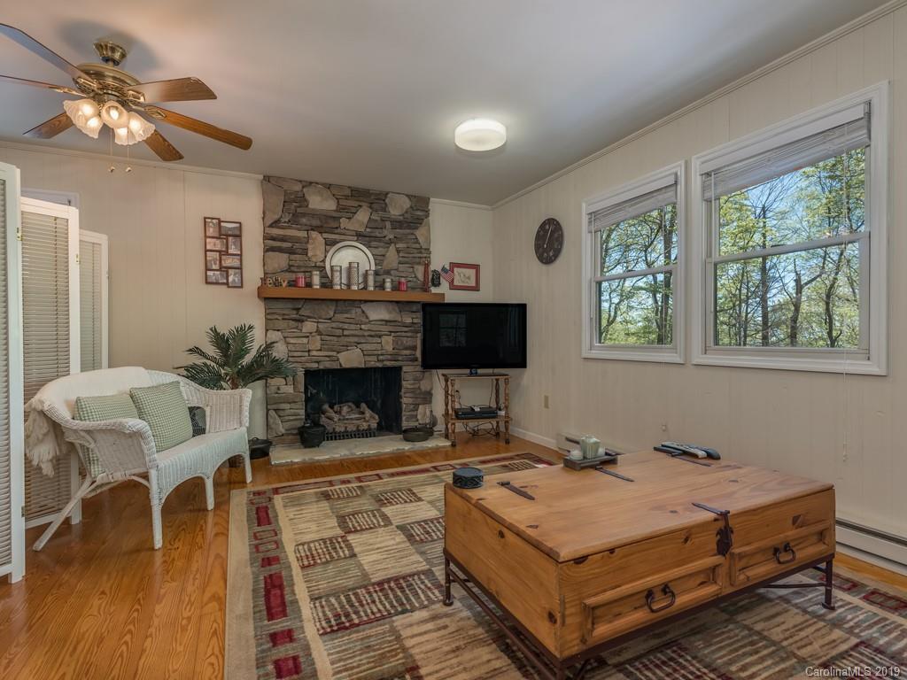 1251 Judes Gap Road Mill Spring, NC 28756 - Photo 14 of 35 a living room with furniture a window and a fireplace