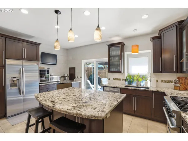 a kitchen with stainless steel appliances kitchen island granite countertop a sink and cabinets
