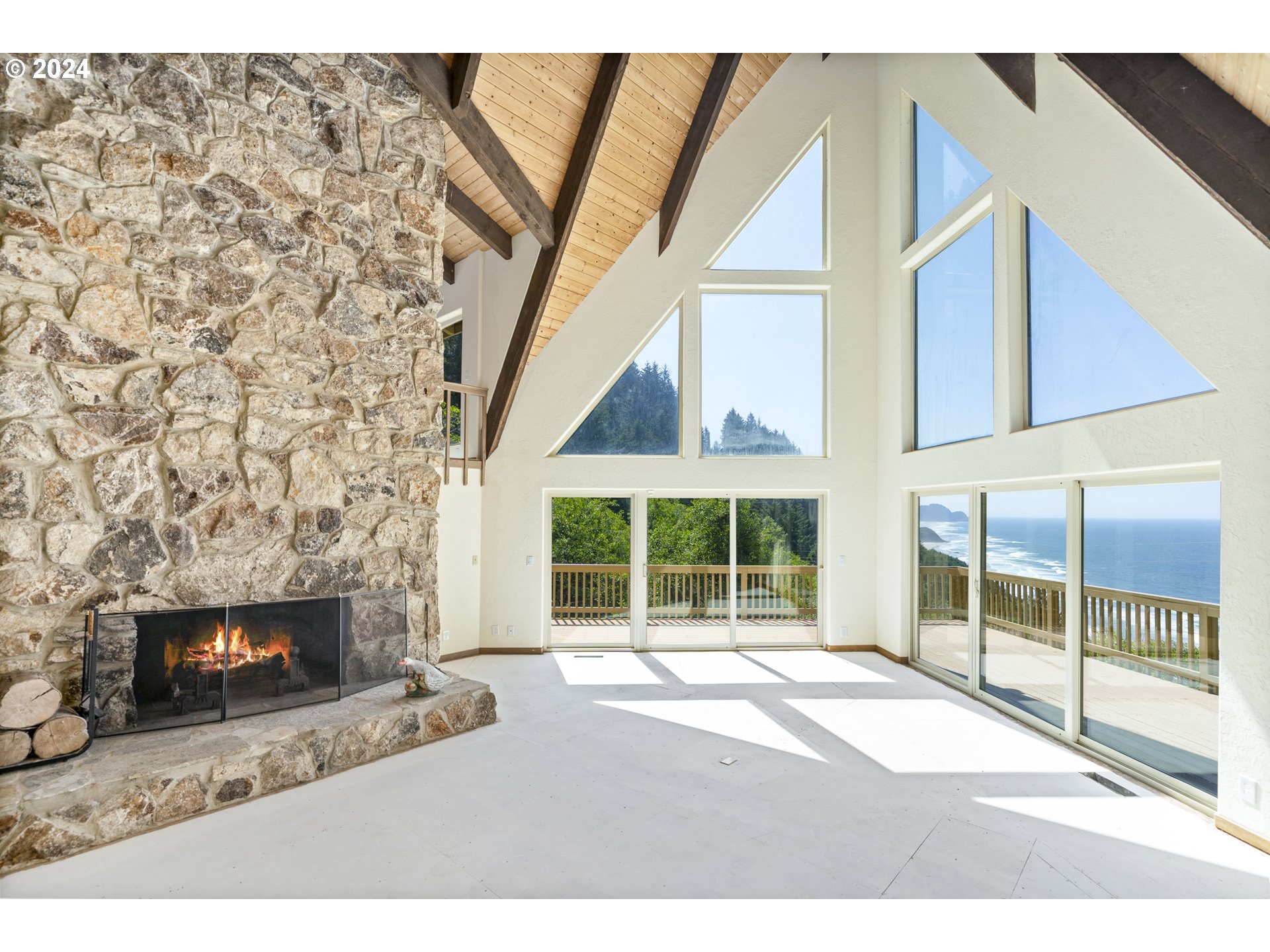 94515 Highway 101 Yachats, OR 97498 - Photo 11 of 45 a living room with a fireplace and a floor to ceiling window