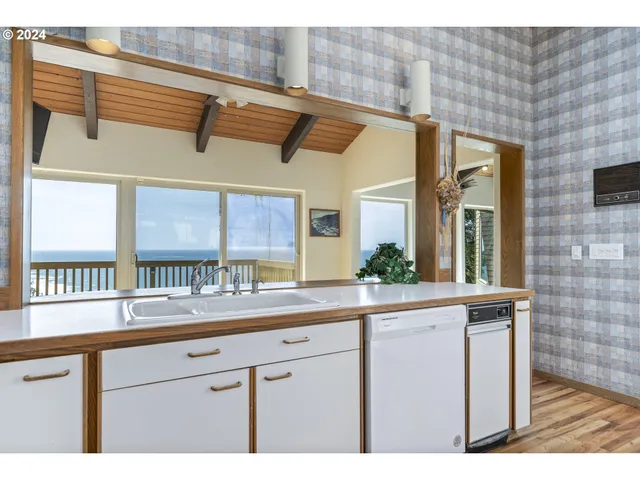 a kitchen with stainless steel appliances kitchen island granite countertop a stove a sink and white cabinets