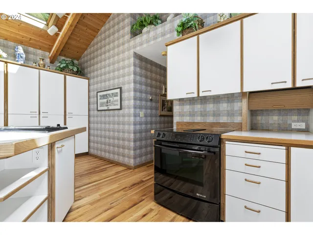 a kitchen with stainless steel appliances kitchen island granite countertop a stove and a sink