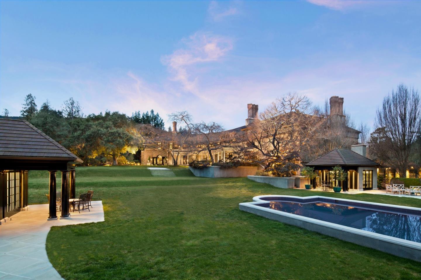 a view of a house with a big yard and sitting area