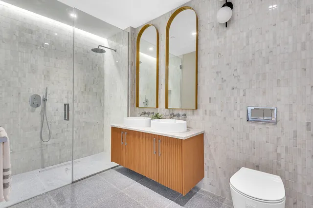 a bathroom with a toilet sink shower and mirror