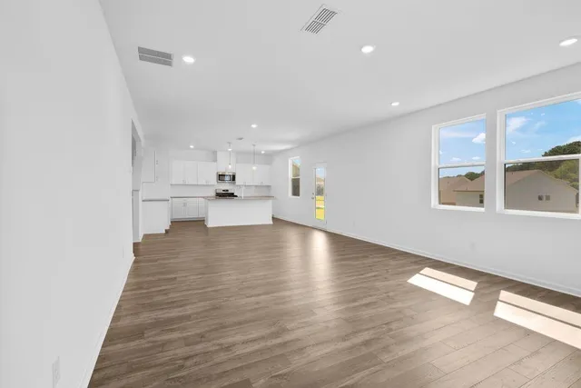 a view of a kitchen with a sink and dishwasher a refrigerator with wooden floor