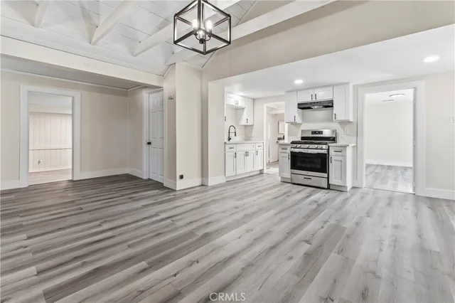 a view of a kitchen with a stove wooden cabinet wooden floor kitchen view and a window
