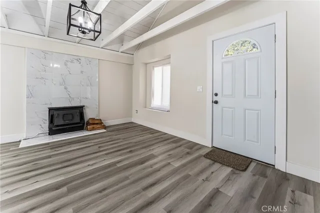 a view of empty room with wooden floor and fireplace