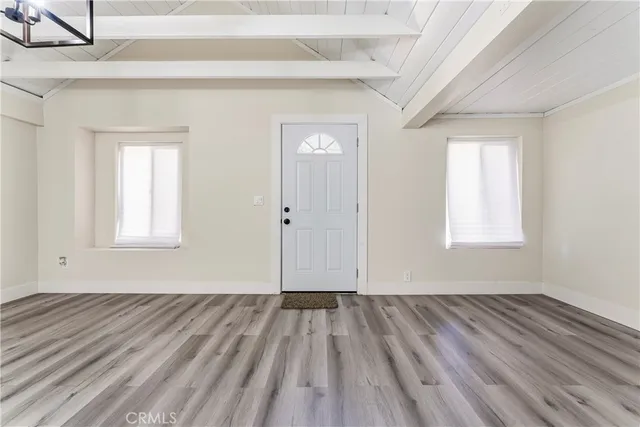a view of a room with wooden floor and window