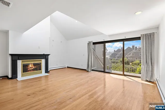 wooden floor fireplace and windows in an empty room