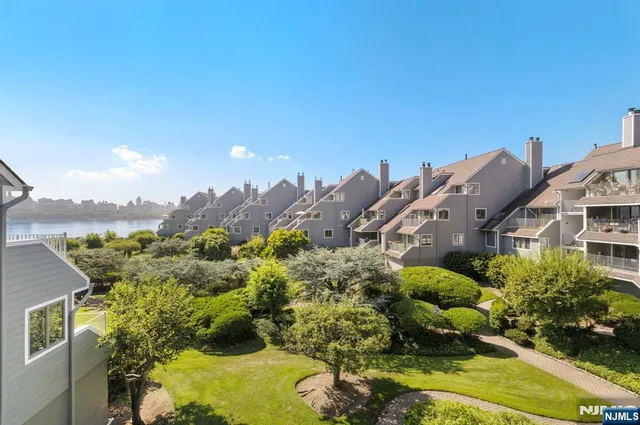a view of a house with a big yard and large tree