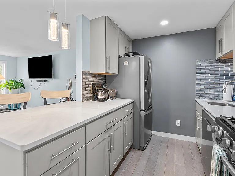 15 Riverview Avenue, Unit D Mashpee, MA 02649 - Photo 10 of 33 a kitchen with stainless steel appliances a refrigerator sink and microwave