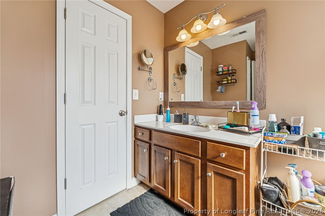 295 Pender Road Spring Lake, NC 28390 - Photo 23 of 30 a bathroom with a sink vanity and a mirror