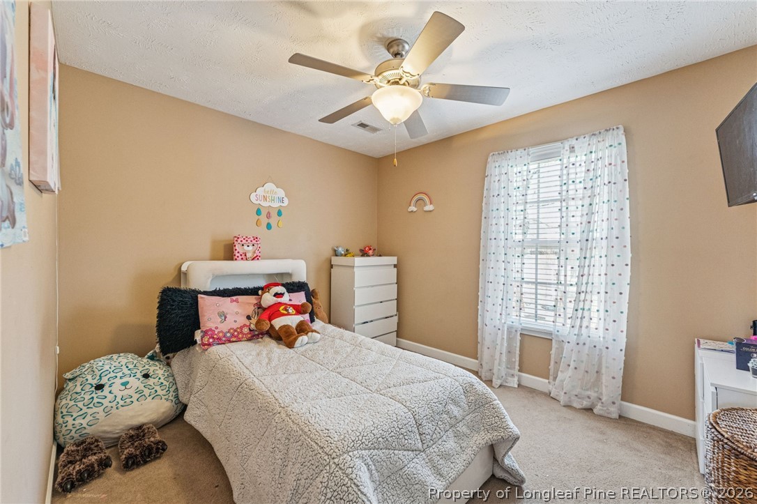 295 Pender Road Spring Lake, NC 28390 - Photo 26 of 30 a bedroom with a bed and a chandelier