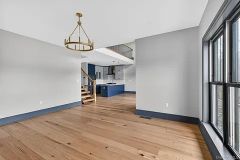 a view of a room with wooden floor a ceiling fan and window