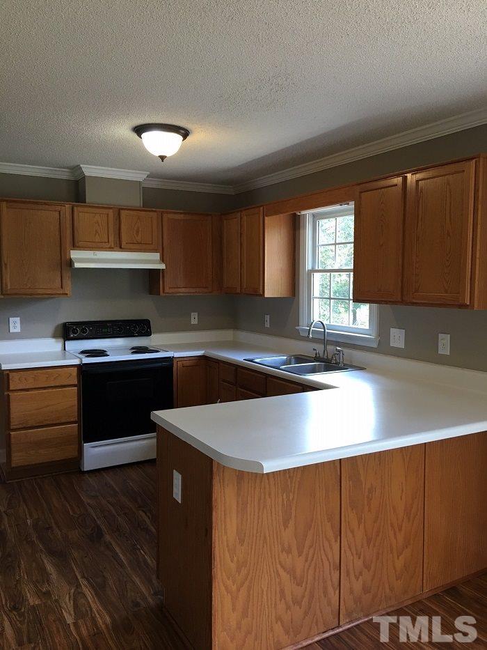 4100 Landrum Lane Raleigh, NC 27616 - Photo 4 of 12 a kitchen with stainless steel appliances granite countertop a stove a sink and a microwave