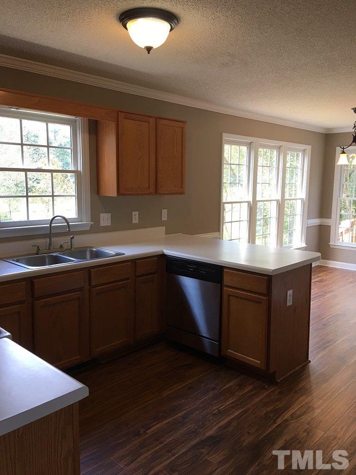 4100 Landrum Lane Raleigh, NC 27616 - Photo 5 of 12 a kitchen with granite countertop a sink window and wooden cabinets