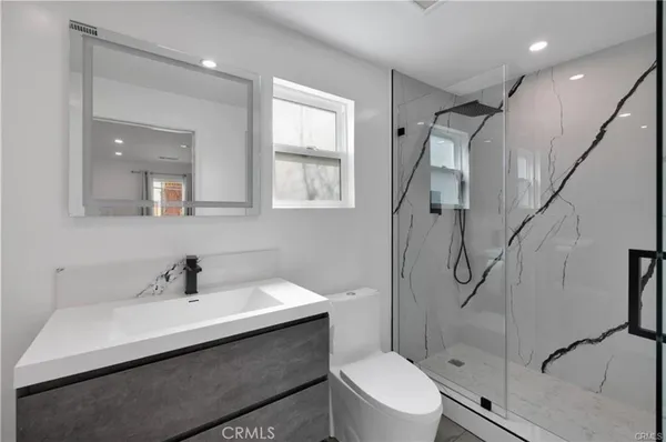 a bathroom with a sink toilet and shower