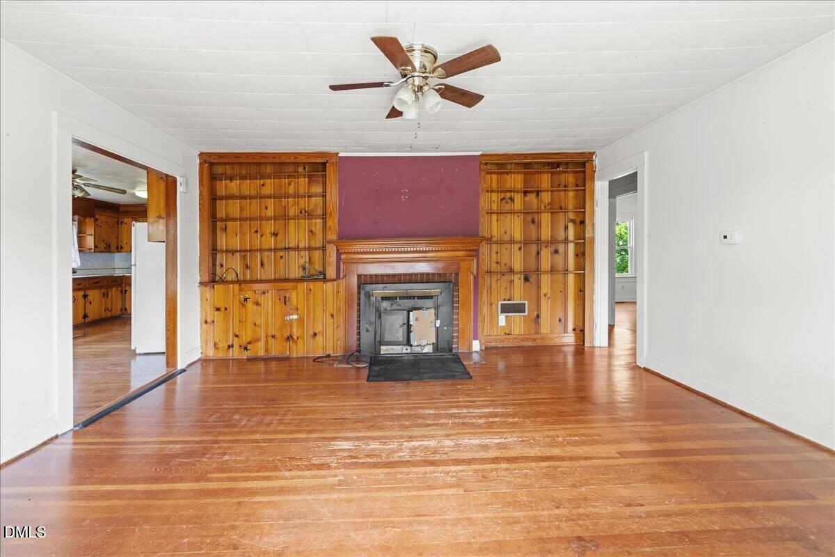 109 Little Ponderosa Road Macon, NC 27551 - Photo 15 of 32 a view of an empty room with a fireplace and a window