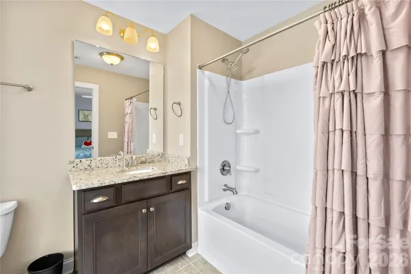 a bathroom with a granite countertop sink a mirror a bathtub and shower