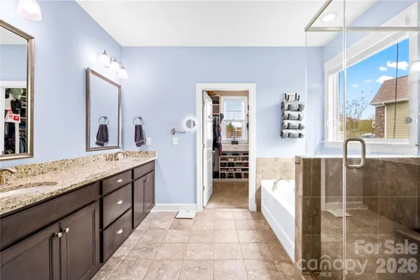 a spacious bathroom with a double vanity sink a mirror and a shower