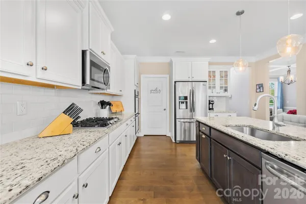 a large kitchen with stainless steel appliances granite countertop a lot of counter space and wooden cabinets